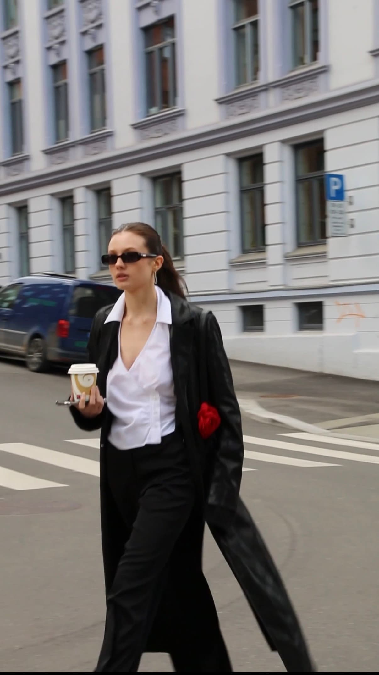 The redesigned garment worn out on the street, coffee in hand.